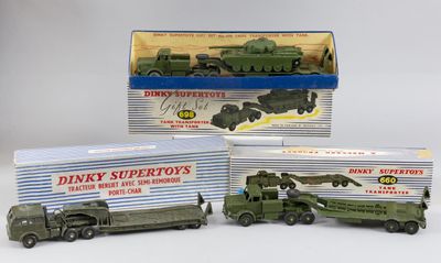 trois véhicules militaires miniatures sont posés dans une boîte sur une surface blanche