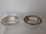 pair of silver plated bowls on display in a glass case