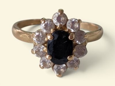 an image of a ring with a black stone surrounded by white diamonds