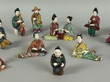 many figurines of asian people sitting in a circle