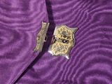 purple satin fabric with a gold badge on top of it