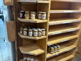 many jars of honey on the shelves in the store