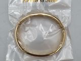 a close up of a gold bracelet on a plastic bag