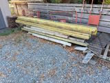 a pile of wood sitting on the ground next to a fence