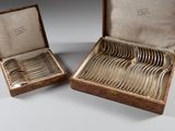 paire de cuillères et fourchettes anciennes en métal argenté, présentées dans un étui