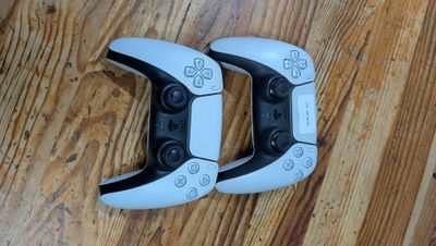 deux manettes de jeux vidéo posées sur un parquet