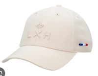 Casquette blanche héritage LXH et sa pochette de rangement.