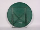 a green plate on a metal stand against a white wall