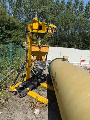 a large yellow pipe laying on the ground next to a fence