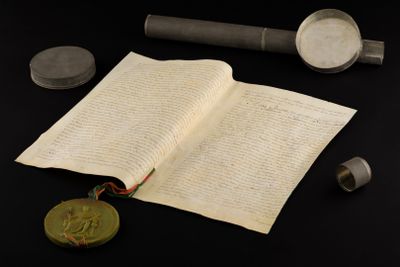 an open book with a wax seal on it next to some other items