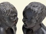 two statues of a boy and a girl kissing each other