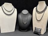 three mannequins with different types of necklaces on display