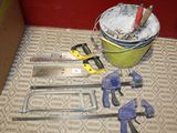 un seau d'outils posé par terre à côté d'un autre seau d'outils