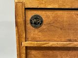 an image of a wooden chest of drawers with metal knobs