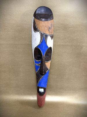 an image of a wooden mask hanging on a wall