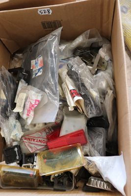 une boîte remplie d'objets hétéroclites posée sur le sol