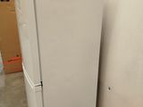 a white refrigerator sitting on a pallet in a room