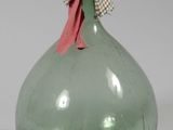 un vase en verre vert orné d'un nœud sur le dessus