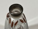 a glass vase that has some brown flowers on it