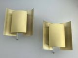 pair of brass wall sconces with curved shades on each of them