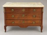 an antique chest of drawers with marble top and brass handles