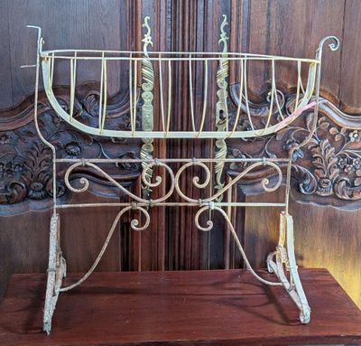 a metal cradle that is sitting on a wooden stand