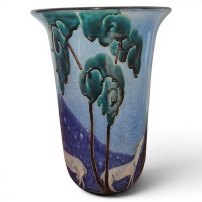 a blue vase with a painting of trees on it