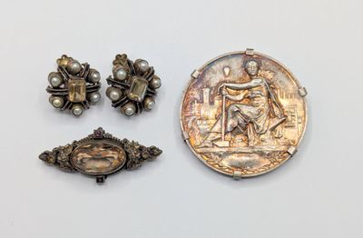 three pieces of silver and pearl jewelry including a coin, broochle, and a broochle