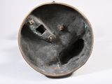 a metal object with a hole in it on a white surface