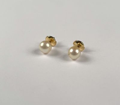 a pair of pearl earrings on a white surface