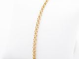 a gold plated bracelet on a white pillow