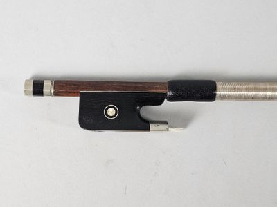 a close up of a violin bow on a white surface