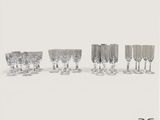 Plusieurs verres à vin sont alignés sur une surface blanche
