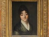 portrait of a young man in a green coat by a gold frame
