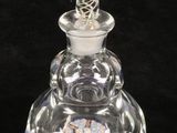 an image of a clear glass perfume bottle with a glass top