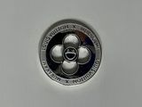 a close up of a silver coin with a flower on it