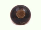 a brown bowl with a brown center on a white surface