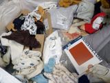 a box full of clothes and other items on the bed