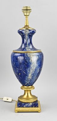 une image représentant un vase bleu et or sur lequel est posée une lampe