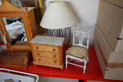 une table rouge sur laquelle se trouvent une lampe et un miroir
