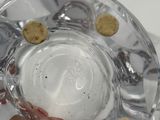 a person holding a glass of water with cookies in it