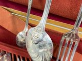 a lot of silverware in a case with spoons and forks in it