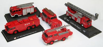 quatre camions de pompiers rouges exposés sur un fond blanc