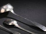trois cuillères et deux petites cuillères posées sur une surface noire