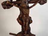 une image représentant une statue en bois d'un homme tenant une croix
