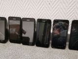 six cell phones are lined up in a row on the floor
