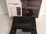 a black nintendo dsx with a pen in front of it
