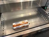 a roll of bread sitting on a conveyor belt in a kitchen