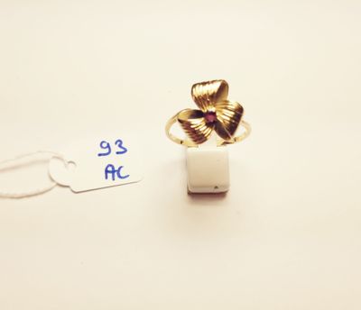a gold ring with a flower on it and a price tag next to it