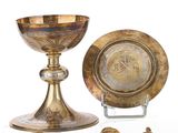 une assiette en or et un bol en argent posés sur un socle